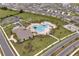 Aerial view showcasing the community pool with palm trees and ample seating in a well-kept landscape at 2043 Rock Maple Bnd, Kissimmee, FL 34746