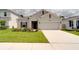 Beautiful one-story home featuring a manicured lawn, flower beds, and a two-car garage at 2043 Rock Maple Bnd, Kissimmee, FL 34746