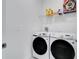 A modern laundry room featuring a washer, dryer, and storage shelves at 2043 Rock Maple Bnd, Kissimmee, FL 34746
