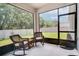 Relaxing screened patio with two rocking chairs and a view of the backyard at 2043 Rock Maple Bnd, Kissimmee, FL 34746