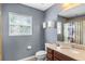 Bathroom featuring large mirror, a window, and vanity with tan countertop at 2122 Bent Grass Ave, Ocoee, FL 34761