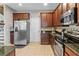 Well appointed kitchen boasts stainless steel appliances, granite countertops, and wood cabinets at 2122 Bent Grass Ave, Ocoee, FL 34761