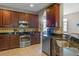 Kitchen features granite countertops, stainless steel appliances, and warm wooden cabinets at 2122 Bent Grass Ave, Ocoee, FL 34761