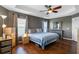 Spacious main bedroom featuring a tray ceiling with ceiling fan and hardwood floors at 2122 Bent Grass Ave, Ocoee, FL 34761