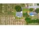 Aerial view of a home with a well-manicured yard, bordered by lush greenery and open fields at 2190 Northland Rd, Mount Dora, FL 32757