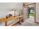 Warm entryway featuring a wooden table with a lamp and decor, complemented by a view of the outdoors at 2190 Northland Rd, Mount Dora, FL 32757