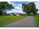 Beautiful single-story home with a well-maintained lawn, long driveway, mature trees, and white picket fence at 2190 Northland Rd, Mount Dora, FL 32757