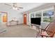 Bright living room with large windows, ceiling fan, wooden door, and a console table with decor at 2190 Northland Rd, Mount Dora, FL 32757