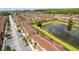 Aerial view showcasing the townhomes, pond, lush landscaping and manicured lawns in the community at 2662 Roadster Ln, Kissimmee, FL 34746