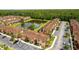 Aerial view of the community featuring townhomes, pond and lush landscaping in a well-maintained neighborhood at 2662 Roadster Ln, Kissimmee, FL 34746