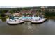 Aerial view of the community pool, pond and clubhouse, surrounded by lush landscaping and manicured lawns at 2662 Roadster Ln, Kissimmee, FL 34746