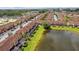 Aerial view showcasing the townhomes, pond, lush landscaping and manicured lawns in the community at 2662 Roadster Ln, Kissimmee, FL 34746