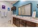Bathroom with dark wood cabinets, light countertops, and blue accent wall at 2662 Roadster Ln, Kissimmee, FL 34746