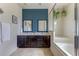 Modern bathroom with double vanity, stylish mirrors, and a shower with a glass door at 2662 Roadster Ln, Kissimmee, FL 34746