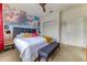 An airy bedroom showcases a cloud mural, a ceiling fan, and a bench for a relaxing atmosphere at 2662 Roadster Ln, Kissimmee, FL 34746