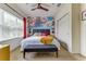 This bedroom features a neutral palette with a cloud mural, ceiling fan, and large window to the outside at 2662 Roadster Ln, Kissimmee, FL 34746