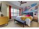 Bright bedroom featuring a modern ceiling fan and a picturesque sky mural for a serene ambiance at 2662 Roadster Ln, Kissimmee, FL 34746
