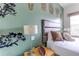Stylish bedroom featuring a unique wall decor, a padded headboard, and a bedside lamp at 2662 Roadster Ln, Kissimmee, FL 34746