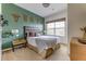 Stylish bedroom featuring a green accent wall, animal art, and a comfortable bed with decorative pillows at 2662 Roadster Ln, Kissimmee, FL 34746
