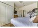 Neutral bedroom with modern decor, tree decal, and a doorway to the en-suite bathroom and closet at 2662 Roadster Ln, Kissimmee, FL 34746