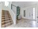 Bright entryway featuring tile flooring, staircase, and neutral decor with white doors at 2662 Roadster Ln, Kissimmee, FL 34746