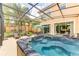 Relaxing screened-in patio features a hot tub, outdoor seating, and an umbrella table perfect for leisure at 2662 Roadster Ln, Kissimmee, FL 34746