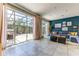Living room featuring sliding doors to screened-in patio, blue wall, and neutral tile floors at 2662 Roadster Ln, Kissimmee, FL 34746