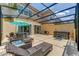 Outdoor screened patio with a hot tub, dining set, and lounge chairs for relaxation and entertainment at 2662 Roadster Ln, Kissimmee, FL 34746