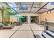 Spacious screened-in patio featuring a hot tub, dining area, and comfortable seating arrangements at 2662 Roadster Ln, Kissimmee, FL 34746