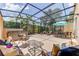Covered and screened-in patio with multiple seating areas, a hot tub, and lush landscaping at 2662 Roadster Ln, Kissimmee, FL 34746