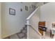 Carpeted stairway with white railing, artwork and a glimpse into the kitchen, leading to the upper level at 2662 Roadster Ln, Kissimmee, FL 34746