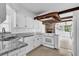 Bright kitchen with granite countertops, white cabinets, and open view of the dining area at 317 Benton St, Orlando, FL 32839