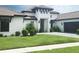 Elegant home showcasing a well-maintained lawn, attractive landscaping, and a welcoming entrance with a covered porch at 4073 Juliana Lake Dr, Auburndale, FL 33823