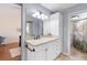 Bright bathroom with white cabinets, double vanity, and mirrored closet for ample storage at 5059 Jamaica Cir # 15, Orlando, FL 32808