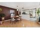 A dining room with a brown accent wall, wood floors, and view into the kitchen at 5059 Jamaica Cir # 15, Orlando, FL 32808