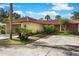 A tan home with a brown garage and red tile roof is surrounded by lush plants at 5059 Jamaica Cir # 15, Orlando, FL 32808