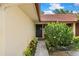 A tan home with a wreath on the storm door, surrounded by pretty bushes and a walkway at 5059 Jamaica Cir # 15, Orlando, FL 32808