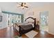 This spacious main bedroom features a ceiling fan, hardwood floors, and access to the patio at 5059 Jamaica Cir # 15, Orlando, FL 32808