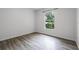 Bright bedroom featuring wood-look flooring, a window with blinds, and neutral paint at 5671 Sycamore Canyon Dr, Kissimmee, FL 34758