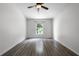 Well-lit bedroom with wood-look floors, a window, and a ceiling fan at 5671 Sycamore Canyon Dr, Kissimmee, FL 34758