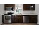 Kitchen features stainless steel appliances, tiled floor, and dark stained cabinets at 5671 Sycamore Canyon Dr, Kissimmee, FL 34758