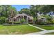 Beautiful home with a well-manicured lawn, mature trees, and a decorative iron gate at 6631 Crenshaw Dr, Orlando, FL 32835