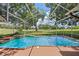 Screened-in pool with an attached hot tub overlooking the lush green golf course at 6631 Crenshaw Dr, Orlando, FL 32835
