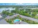 Aerial view of apartments with a pool, lush landscaping, and a lake in the background at 754 E Michigan St # 182, Orlando, FL 32806