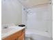 A simple bathroom featuring a sink with a vanity and a bathtub with white tiling and shower head at 754 E Michigan St # 182, Orlando, FL 32806