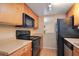 Kitchen featuring wood cabinets, black appliances and tile floors at 754 E Michigan St # 182, Orlando, FL 32806