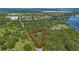 Aerial view of a house surrounded by lush greenery and near a lake at 7838 Sloewood Dr, Mount Dora, FL 32757