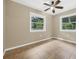 Neutral bedroom with tile floors, ceiling fan, and natural light from the windows at 7838 Sloewood Dr, Mount Dora, FL 32757