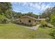 Landscaped home exterior with lush lawn and a charming walkway at 7838 Sloewood Dr, Mount Dora, FL 32757