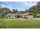 Charming single-story home with a well-manicured lawn, mature trees, and an attached two-car garage at 7838 Sloewood Dr, Mount Dora, FL 32757